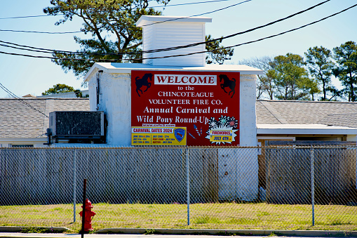Chincoteague Island, Virginia, USA - March 21, 2024: An information sign advertises the “Annual Carnival and Wild Pony Round-Up” held at the Chincoteague Carnival Grounds where the famous Chincoteague Ponies are auctioned off each summer by the Chincoteague Volunteer Fire Company.