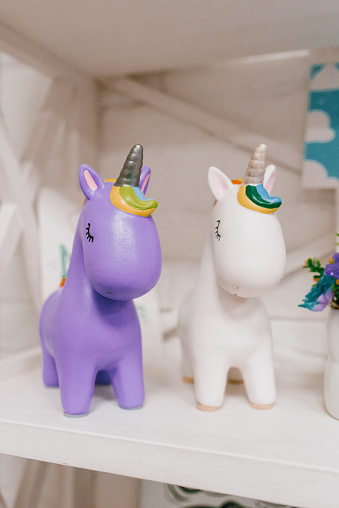 Figurines of a white and lilac unicorn on a shelf in the children's room
