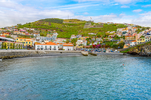 The picturesque seaside fishing village of Câmara de Lobos, Portugal, Canary Islands, with it's pebble beach and colorful town of shops and cafes.