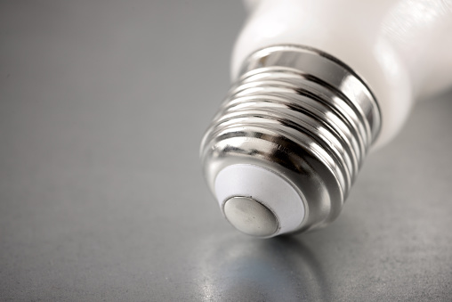 Close up of an energy-saving light bulb socket on a metal surface