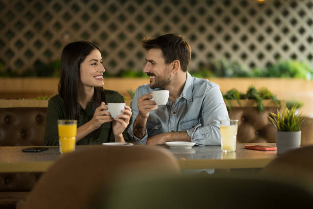 istock Young couple drinking coffee and talking while dating in a cafe. 2123100042