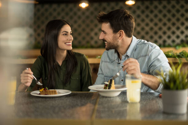 istock Happy young couple enjoying cakes and drinks in a restaurant. 2123104793