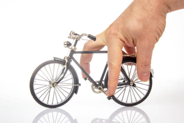 istock man hand on a bicycle model on a white background. cycling concept 2123123410