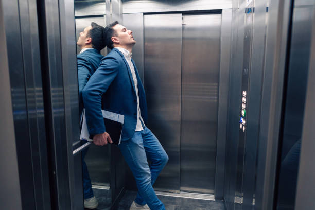 istock Overworked Caucasian businessman in the elevator 2123155182