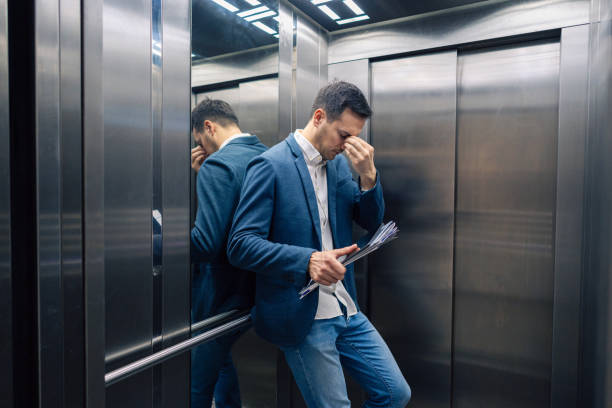 istock Tired Caucasian businessman in the elevator 2123155194