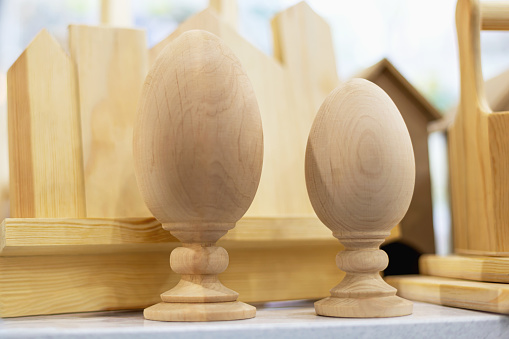 Mockup of unpainted wooden egg decorations on blurred woodwork background. Do-it-yourself or DIY concept, woodworking or celebrating cultural holidays such as Easter