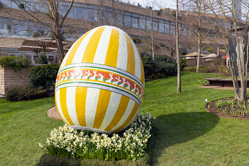 Large decorotive Easter egg on the grass in the park. Easter concept. Copenhagen, Denmark - March 28, 2024