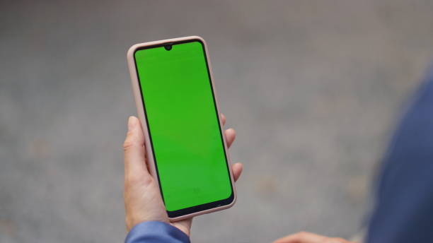 istock Woman hand touching chroma key screen outdoors closeup. Finger tapping chat cell 2123218562