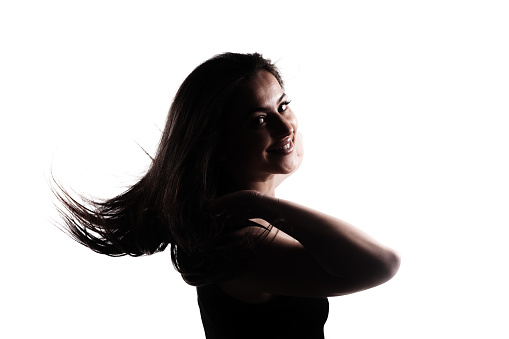 Silhouette of a young woman with long hair in the air. Isolated on white background.