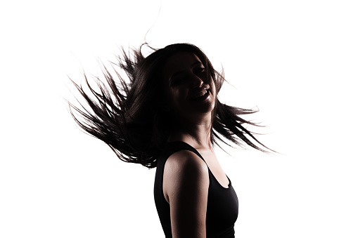 Silhouette of a young woman with long hair in the air. Isolated on white background.