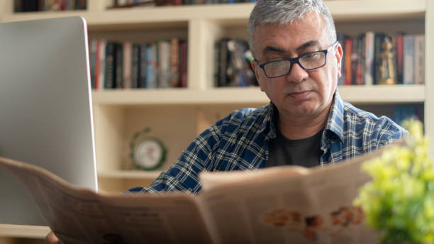 istock businessman reading newspaper at office 2123263824