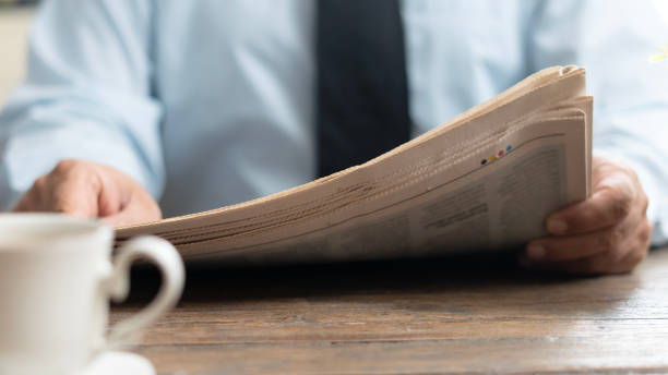 istock businessman reading newspaper at office 2123265374