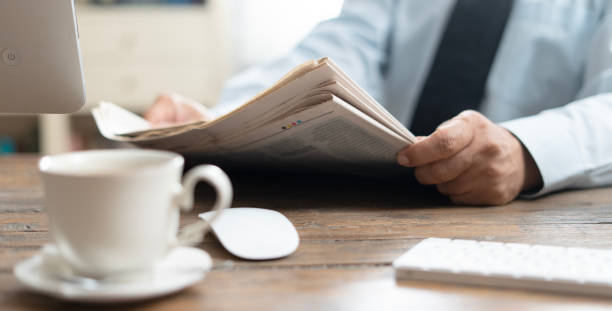 istock businessman reading newspaper at office 2123265377