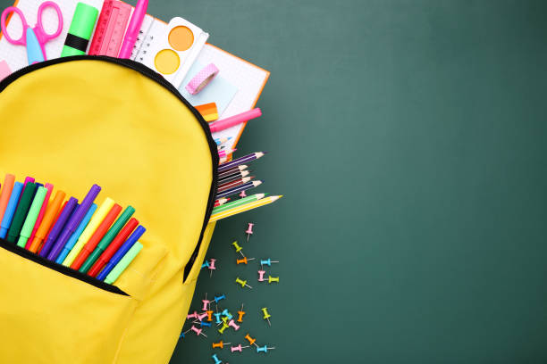 istock Backpack with school supplies on green background 2123270568