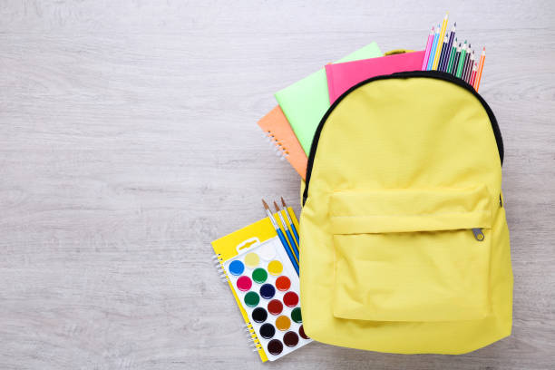 istock Backpack with school supplies on wooden table 2123273145