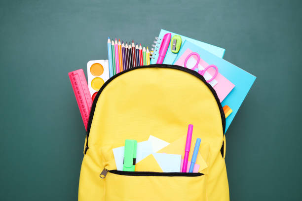istock Backpack with school supplies on green background 2123273663