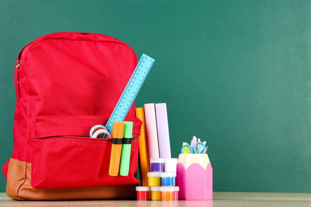 istock Backpack with school supplies on chalkboard background 2123286069