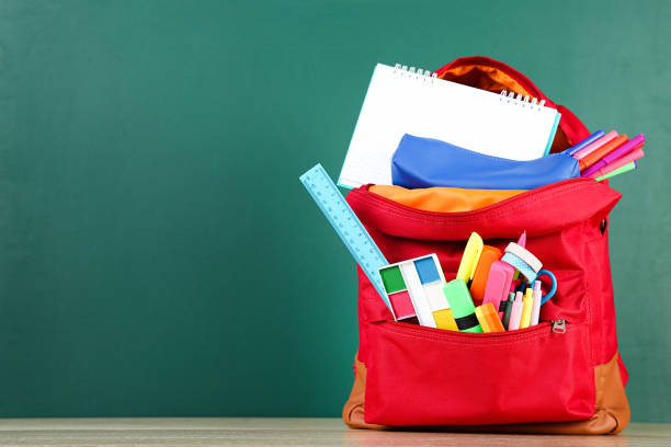istock Backpack with school supplies on chalkboard background 2123294788