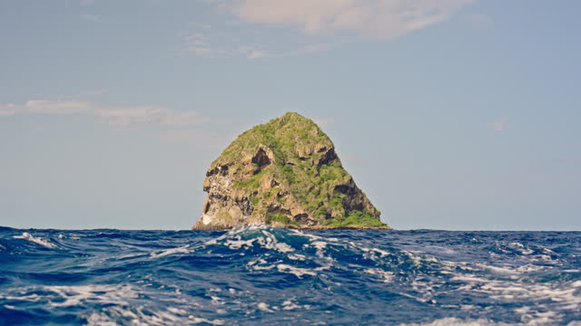 Boat Point of View of Huge Mossy Stack Rock in Blue Wavy Seascape against Sky during Sunny Day