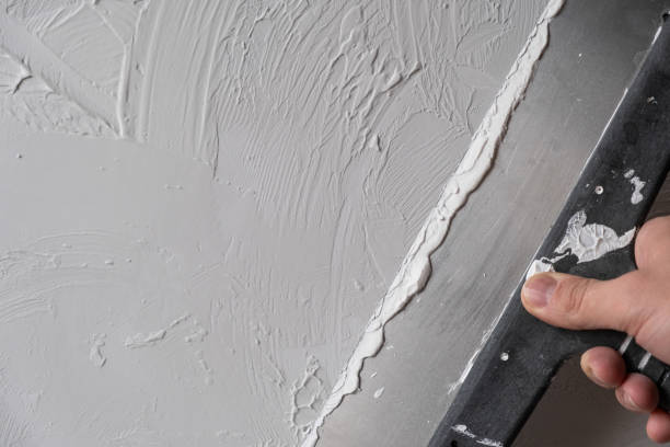istock Applying decorative putty. White abstract texture of surface covered with putty 2123317076