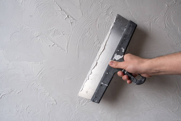 istock Applying decorative putty. White abstract texture of surface covered with putty 2123318116