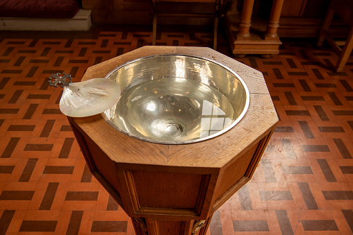 Colour image of wooden baptismal font with silver bowl.