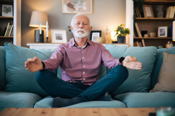 istock senior man meditates at home. 2123410316
