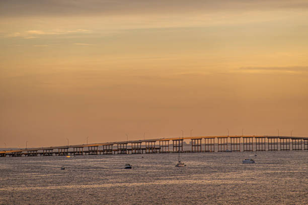 Miami, Florida, USA - July 29, 2023: William M Powell Bridge under orange sunset sky. A few yachts present