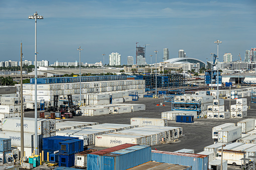 Miami, Florida, USA - July 29, 2023: Port. Stacks of Seaboard containers fill terminal grounds under blue evening cloudscape. Buildings on horizon