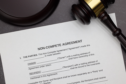 Non-Compete agreement legal form with gavel and block on slate desktop