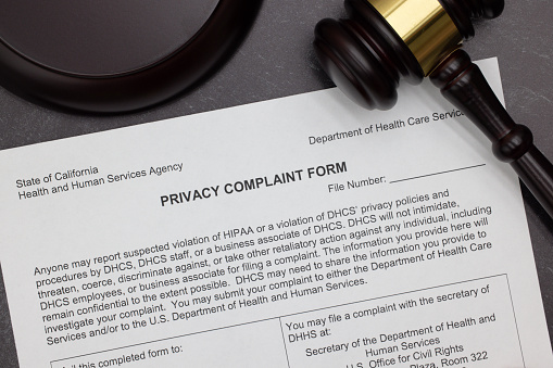 HIPPA Privacy Complaint legal form with gavel and block on slate desktop