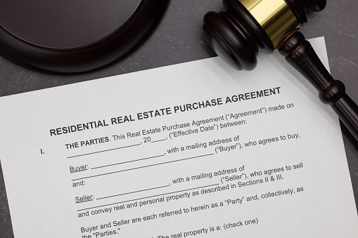 Residential Real Estate Purchase Agreement legal form with gavel and block on slate desktop