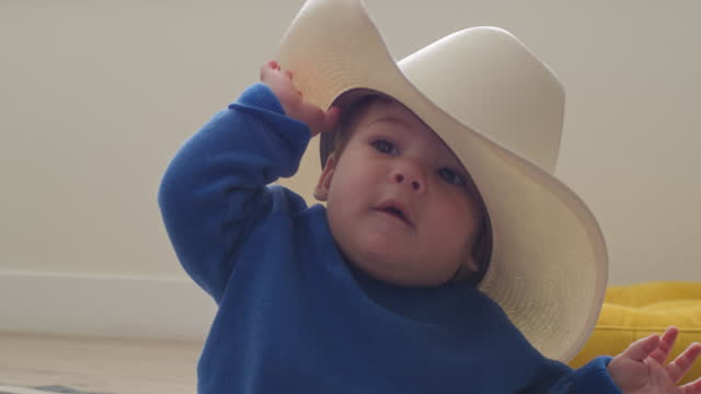 Baby boy playing with a cowboy hat