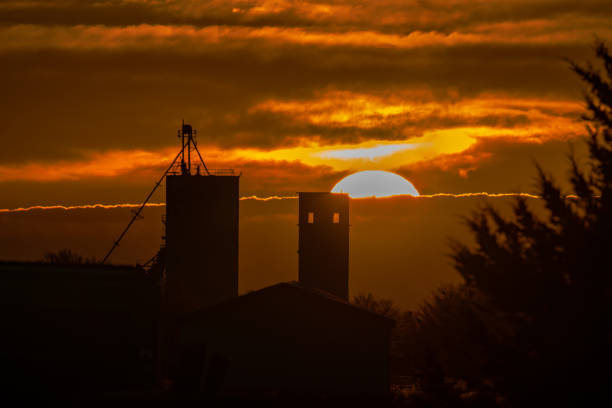 Sun rising over a couple old grain elevators