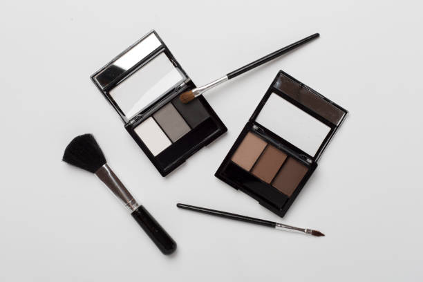 istock Eye shadows with brushes on color background, top view 2123588087