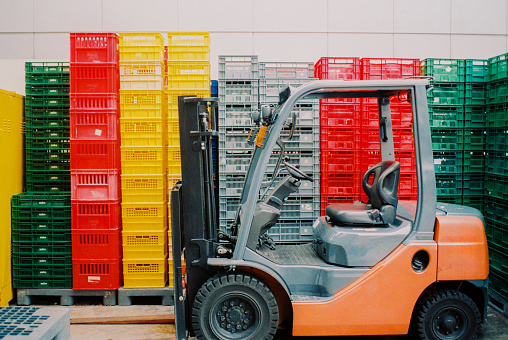 Forklift on the background of colourful containers shot on camera film