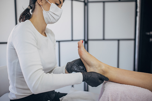 Capture the essence of relaxation with a professional pedicure session. This image showcases a skilled pedicurist providing a soothing foot massage in a salon setting. Treat yourself to the ultimate pampering experience and rejuvenate your tired feet