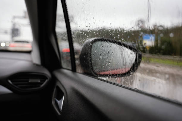 istock Raindrops reflected on the car glass and rearview mirror on a rainy day 2123893000