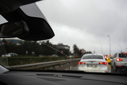 Raindrops reflected on the car glass and rearview mirror in Istanbul traffic on a rainy day