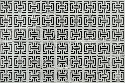 Concrete white roster or breeze block or breeze wall, in greek key pattern or meander pattern, with a touch of Chinese modern geometric pattern and cross tees pattern. This breeze block is often applied at building façade