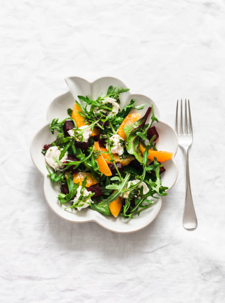 istock Delicious salad with beetroot, arugula, cheese and oranges on a light background, top view 2124148013