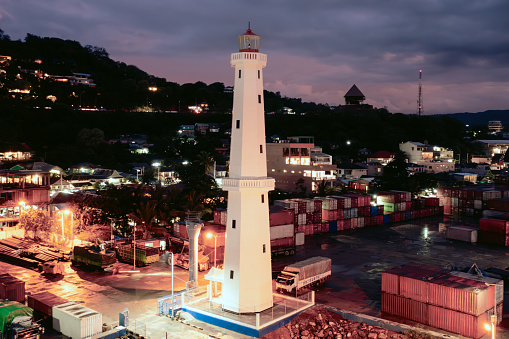 Illuminated old Lighthouse at the Harbor of Labuan Bajo at Night. Illuminated Lighthouse Tower at the transportation harbor of Labuan Bajo, Capital City of Flores Island and Gateway to the Komodo National Park. Lighthouse Bajo, Labuan Bajo, East Nusa Tenggara, Flores Island, Lesser Sunda Islands, Indonesia, Southeast Asia.
