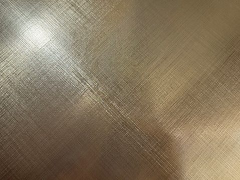 Golden stainless steel reflective texture. Texturized steel with hairline pattern, gold luxury and lush steel.