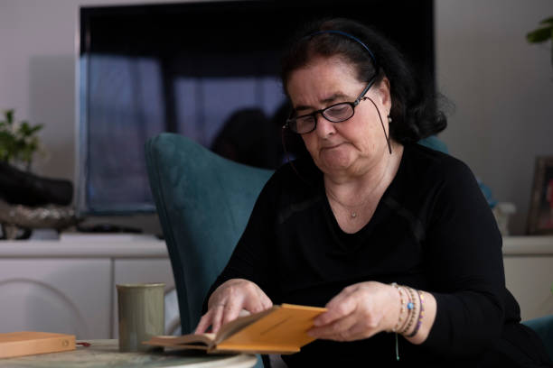 istock Senior women reading a book alone at home. 2124253636