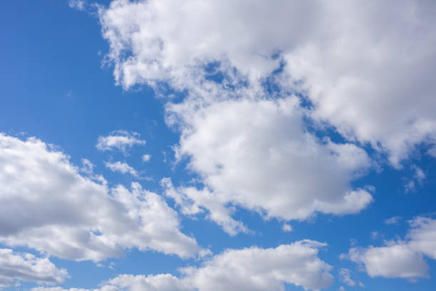 White fluffy clouds in the blue sky at sunny day