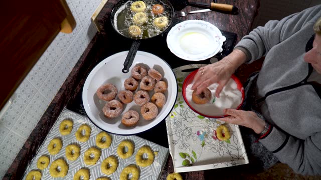 Grandma sugaring the delicious homemade donuts