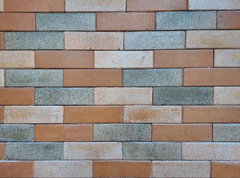 Pressed and honed Red orange brickwall texture on an exposed wall with cement and natural contour.