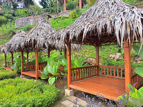 Typical tropical modern gazebo with wooden floors, timber structure, straws ceiling and palm thatch roof.