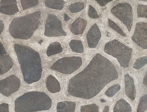 Cobblestone or paving stone flooring with white cements, stone slab cut in irregular patterns and solidified with cements to be a natural stone flooring.