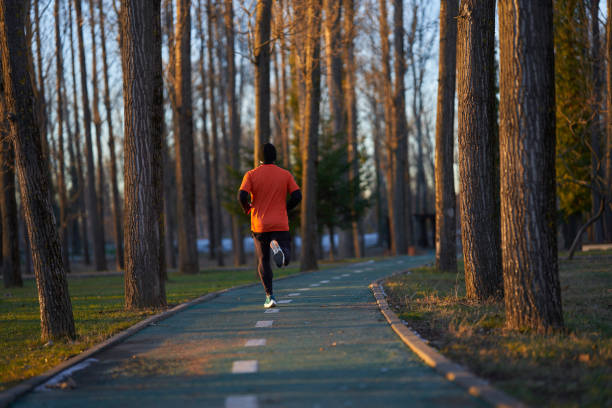 istock Athlete running in the park, view from back 2124331495